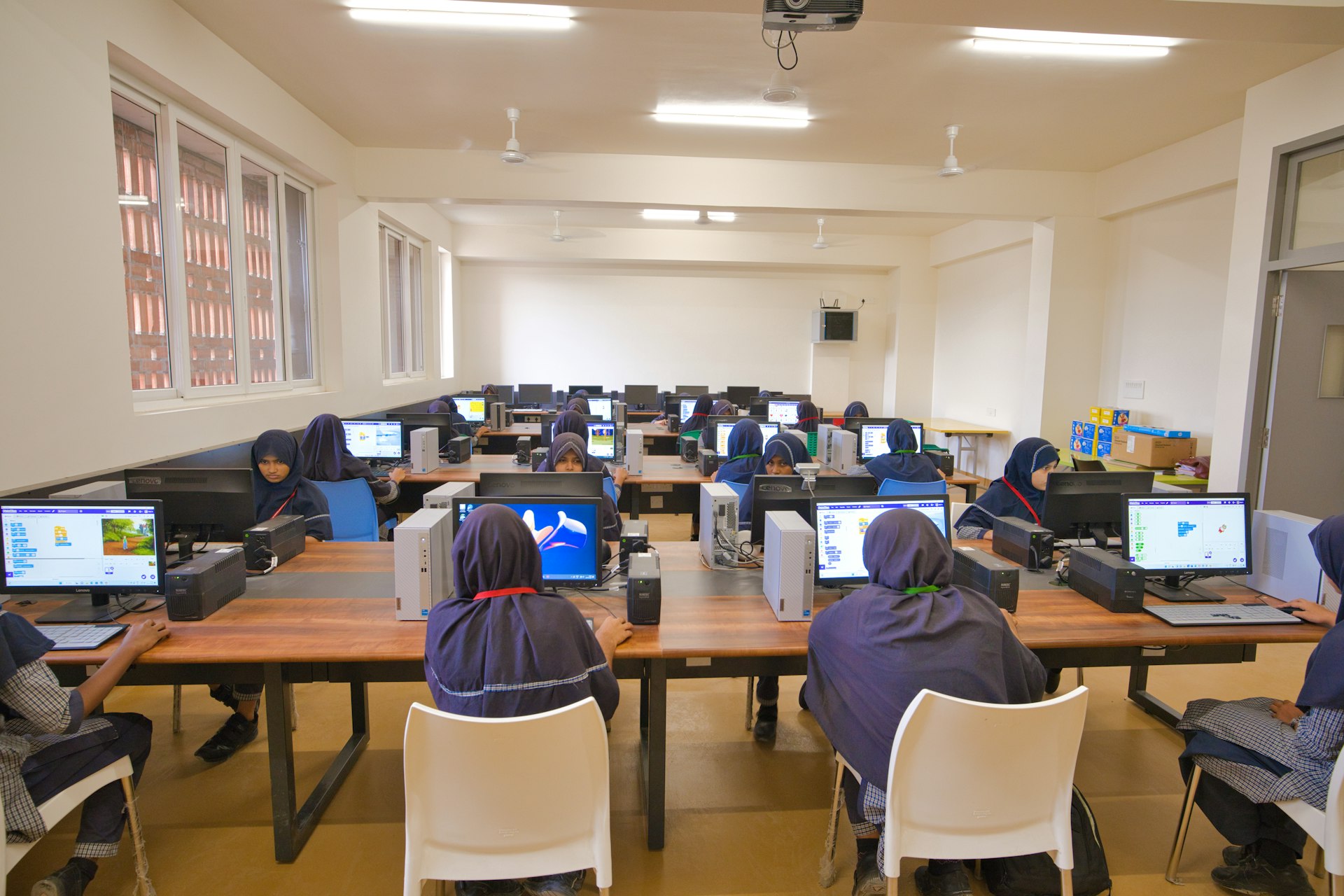 A group of people sitting at desk with laptops